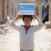 Un niño de 12 años lleva una caja con jabón suministrado por las Naciones Unidas en el barrio de Bani Harith de Sana'a, en Yemen.