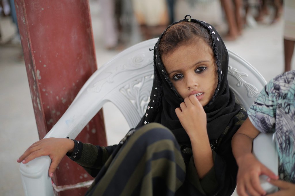 طفلة تنتظر توزيع الإمدادات الإنسانية الطارئة التي تدعمها اليونيسف في الحديدة، اليمن - حزيران/يونيو 2018.