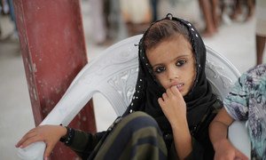 A child waits as UNICEF-supported emergency humanitarian supplies are distributed in Hudaydah, Yemen in June 2018.