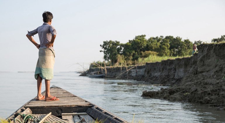 Un garçon regarde le rivage depuis un bateau près de Sirajganj, une communauté touchée par une grave érosion qui a laissé de nombreuses personnes déplacées. Sirajganj, Bangladesh