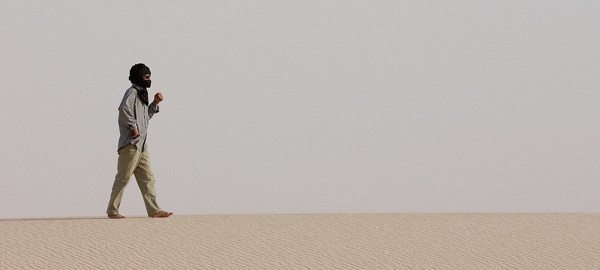 رجل يسير على طريق صحراوي في شمال أفريقيا