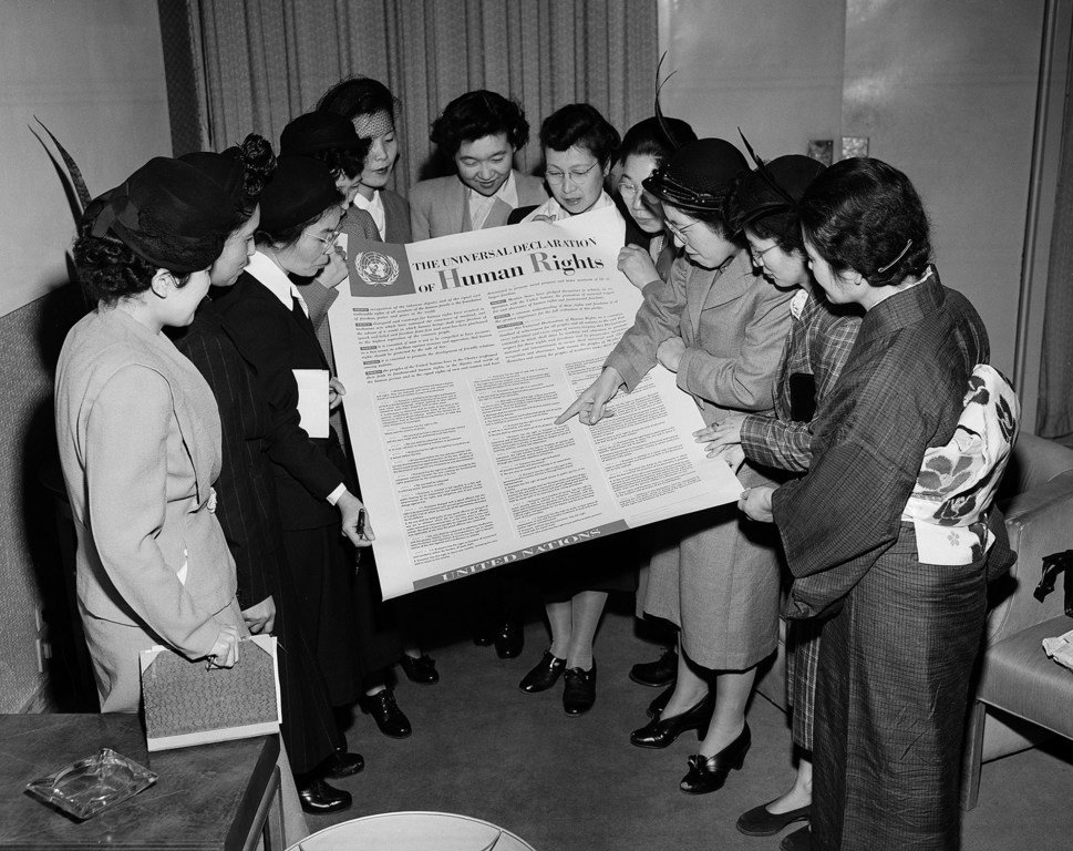 一群日本妇女在1950年2月访问联合国位于Lake Success的临时总部期间阅览《世界人权宣言》。