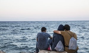 希腊莱斯沃斯岛，几位移民眺望着大海。