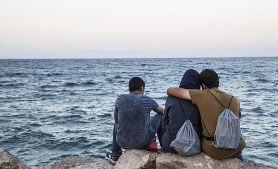 Migrants look out to sea in Lesbos, Greece. 