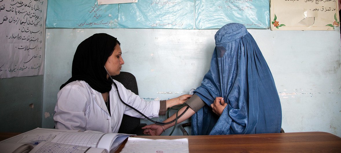 阿富汗29岁的助产士穆赫达在一个诊所里检查22岁的怀孕妇女索拉雅。照片摄于2012年。