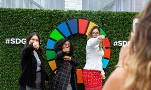 Participant of events held on the first day of the high-level week of the seventy-third session of the General Assembly pose in front of the Sustainable Development Goals emblem. 24 September 2018.
