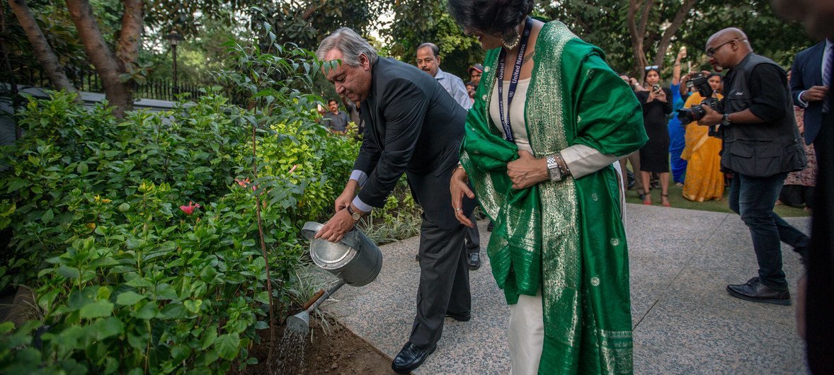 联合国秘书长古特雷斯在新启用的联合国驻印办事处庭院内为一株刚刚植好的树木浇水。