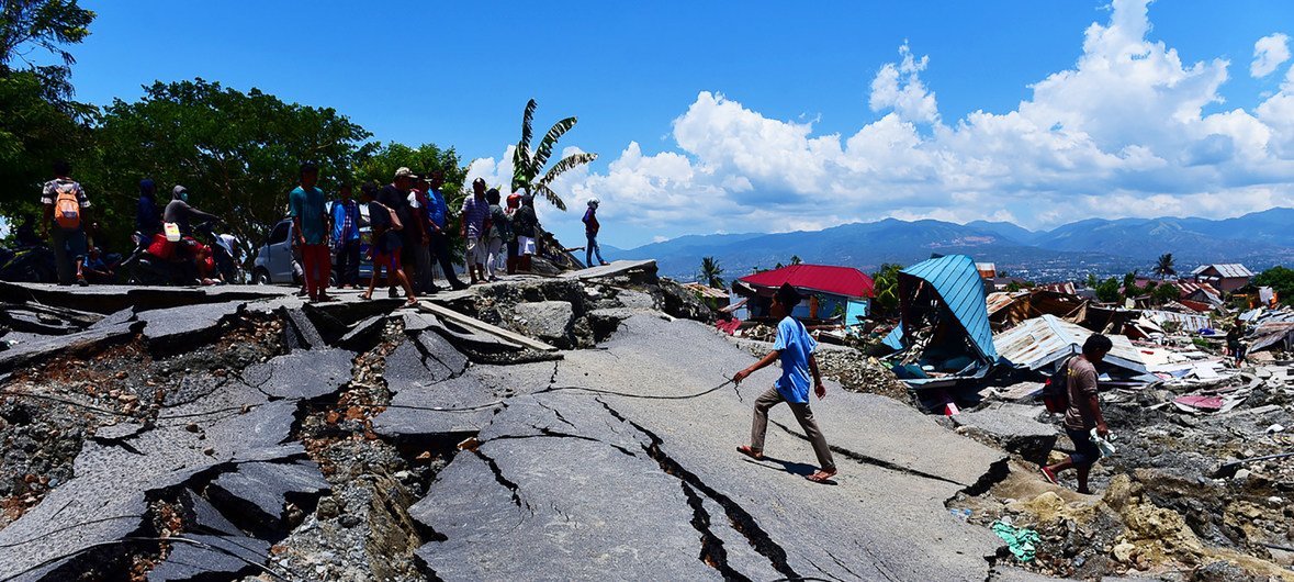 People cross a damaged road in Balaroa, West Palu, Central Sulawesi, after the earthquake and tsunami that struck Sulawesi on 28 September 2018.