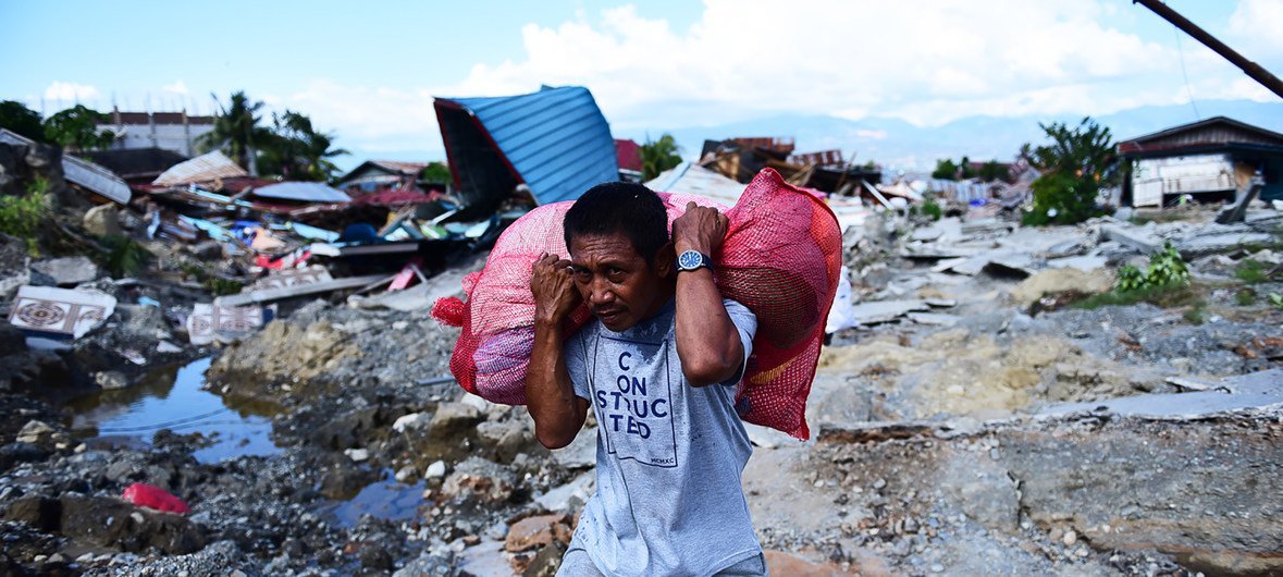 Residents carry possessions salvaged from the rubble of homes in West Palu, Central Sulawesi, after the earthquake and tsunami that struck Sulawesi on 28 September 2018.