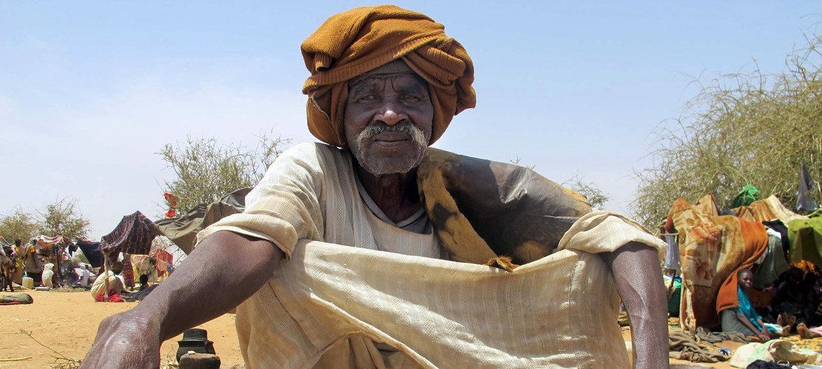 السيد هارون جمعة بحر، رجل يبلغ من العمر 70 عاما فر من قرية كوبي، في صورة بجوار قاعدة اليوناميد في كورما، شمال دارفور. 25 آذار/مارس 2014.