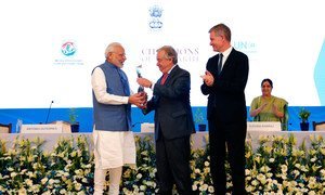 Secretary-General António Guterres (centre) honors Prime Minister Narendra Modi of India with the Champion of Earth award, the highest environmental honour of the United Nations, at Pravasi Bharatiya Kendra in New Delhi. UN Environment Executive Director Erik Solheim (right) looks on.