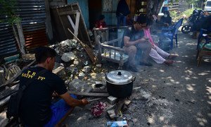 A resident cooks in front of their house with simple equipment because they are still worried that there will be aftershocks in East Lolu, Palu City, Central Sulawesi, Indonesia (2 October).