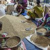 Des femmes trient des céréales sur un marché de Mumbai, en Inde