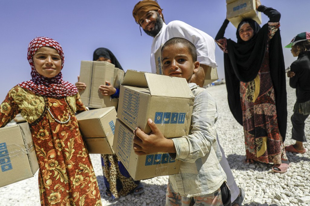 Une famille reçoit des vêtements de l'UNICEF dans le camp de fortune de Mabrouka, en Syrie, en août 2018.