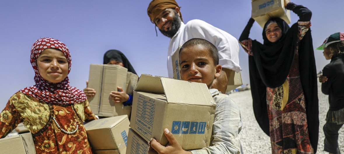 Una familia recibe una donación de UNICEF en un campamento de desplazados internos en Mabrouka, en la provincia de al-Hasakah, Siria.