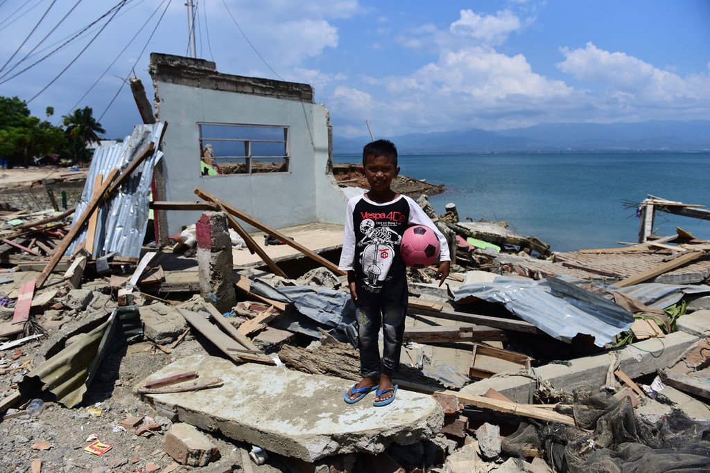 Rido Saputra, 10 ans, devant son domicile détruit par le tsunami dans le Sulawesi central, en Indonésie