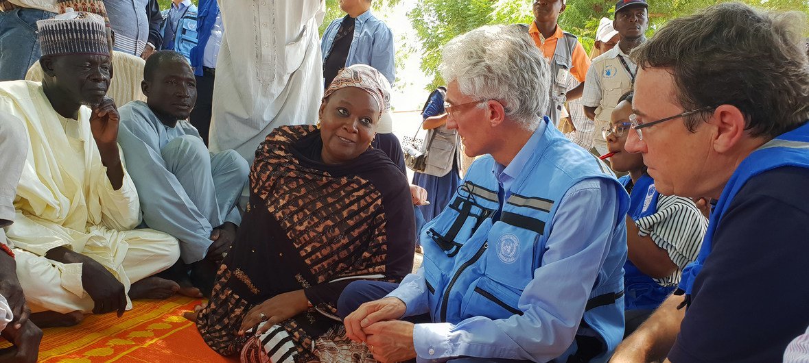 UN Emergency Relief Coordinator Mark Lowcock (2nd r) and UNDP Administrator Achim Steiner (r) with the head of the Nigeria State Emergency Management Agency (middle), speaking with a group of farmers from the border town of Banki in Borno state, Nigeria on 6 October 2018.
