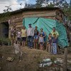 A family of Venezuelan children and their older Colombian-born relatives stand outside their wooden house in Barrio Camilo Daza in the city of Cúcuta, Colombia. Mother of four, Aide Caceres (far left) recently brought her children here because of the situ