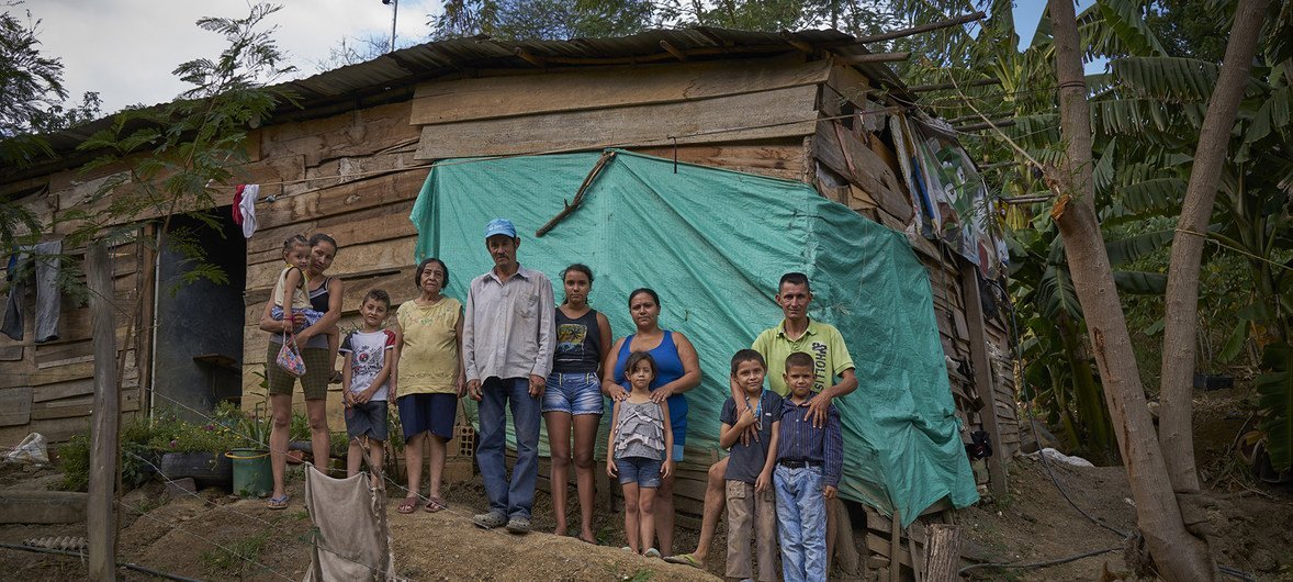 A family of Venezuelan children and their older Colombian-born relatives stand outside their wooden house in Barrio Camilo Daza in the city of Cúcuta, Colombia. Mother of four, Aide Caceres (far left) recently brought her children here because of the situation in Venezuela, but is unable to access health and education for them as they are undocumented Venezuelans.