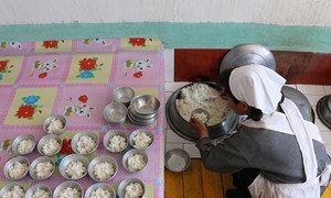  2018年5月，一名工作人员在朝鲜南部一所由世界粮食计划署支援的托儿所里准备饭菜伙食。