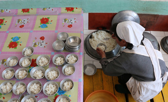 Trabalhadora humanitária prepara refeição para crianças financiada pelo PMA em Hwanghae Sul, na Coreia do Norte. 