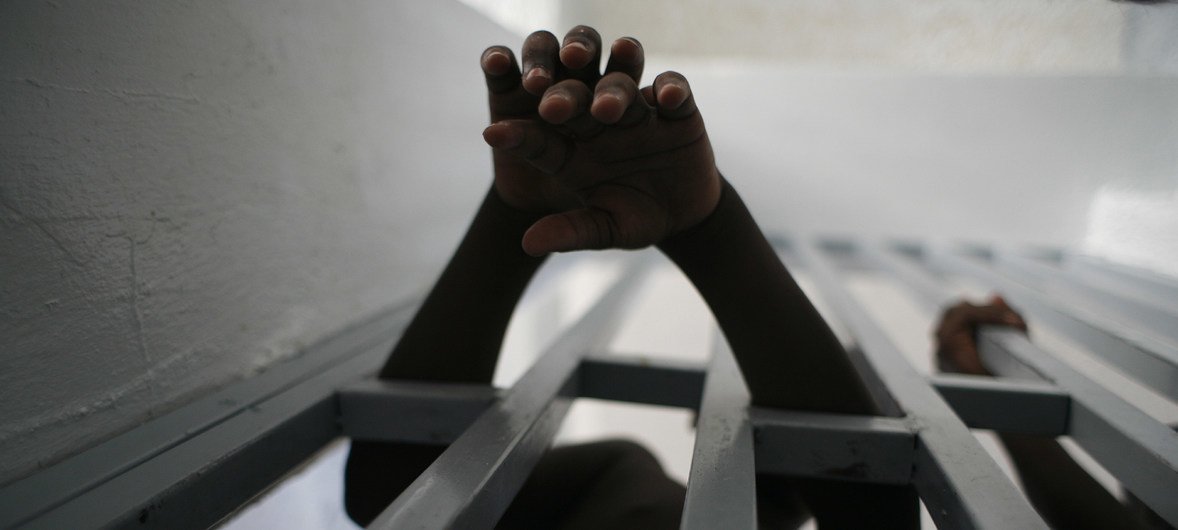 [ARCHIVO] Joven prisionero saca sus manos a través de los barrotes de una cárcel 