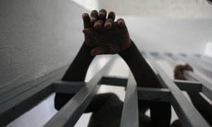 हेती की एक जेल में बन्द एक लड़का बाहर की दुनिया से सम्पर्क बनाने की कोशिश करता हुआ, तस्वीर 2005 की है.