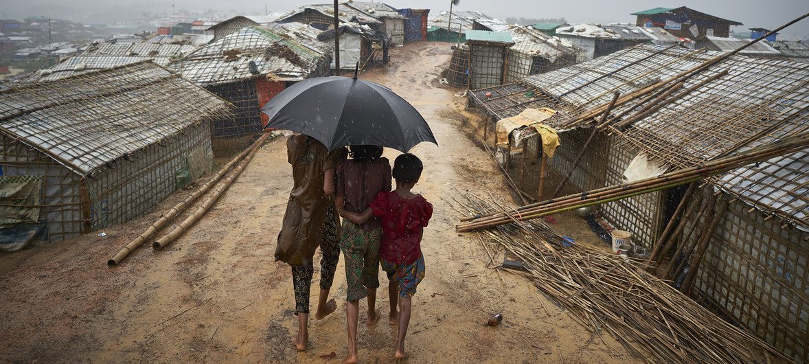 Rohingya refugees make their way down a footpath during a heavy monsoon downpour in Kutupalong refugee settlement, Cox's Bazar district. 2018.