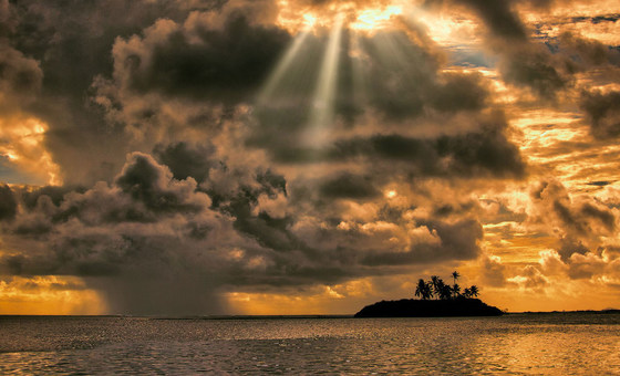 O nascer do sol e uma nuvem de chuva reunem-se no atol de Laamu, Maldivas.