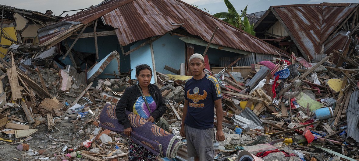 印尼苏拉威西岛帕鲁的贝托波村，31岁的地震幸存者美佳（Mega，左）与丈夫来到昔日她从小长大的屋子，在废墟中搜寻可用的物品。