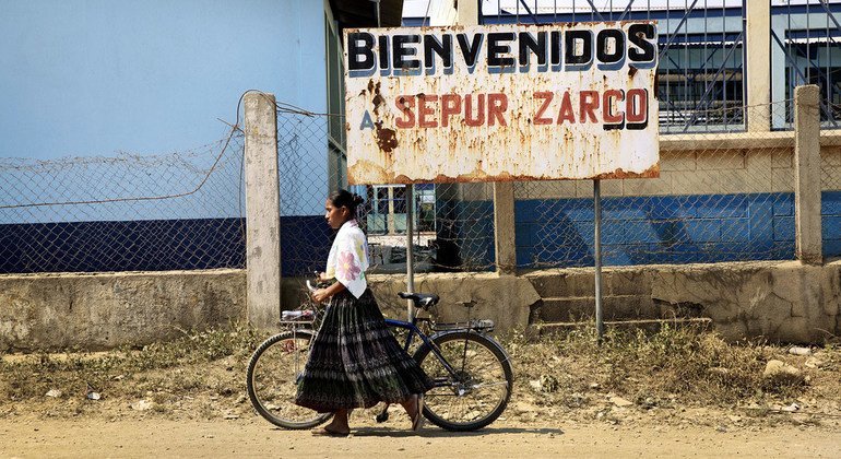 An indigenous woman walks her bicycle in Guatemala.