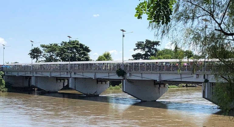 Migrantes centroamericanos cruzan uno de los puentes que conecta Guatemala con México.