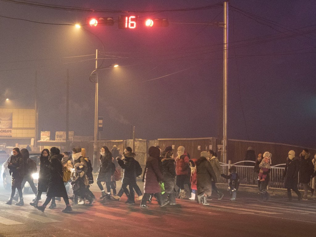 蒙古乌兰巴托索格诺克哈尔克汗（Songinokhairkhan）区，凌晨时分，父母带着孩子穿过马路前往学校，该区是乌兰巴托市空气污染最为严重的地区。