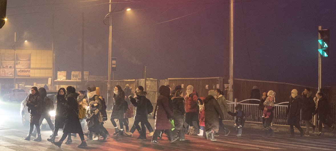 At dawn, parents and children cross the road on their way to school in the Songinokhairkhan district, Ulaanbaatar, Mongolia, where the air pollution level is the highest in the city.
