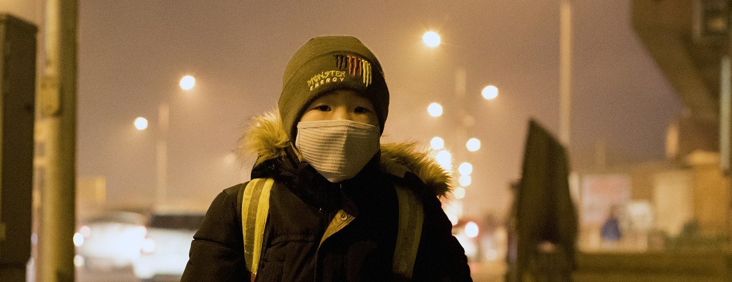 Un niño esperando el autobús para ir a la escuela en la ciudad mongola de Songinokhairkhan, donde los elevados niveles de contaminación del aire son peligrosos.