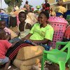 Nadine and her children, Congelese nationals expelled from Angola, rest on their luggage in Kamako, near the border between Angola and the Democratic Republic of the Congo. Nadine needs money to pay for onward transport but, like thousands of families, sh