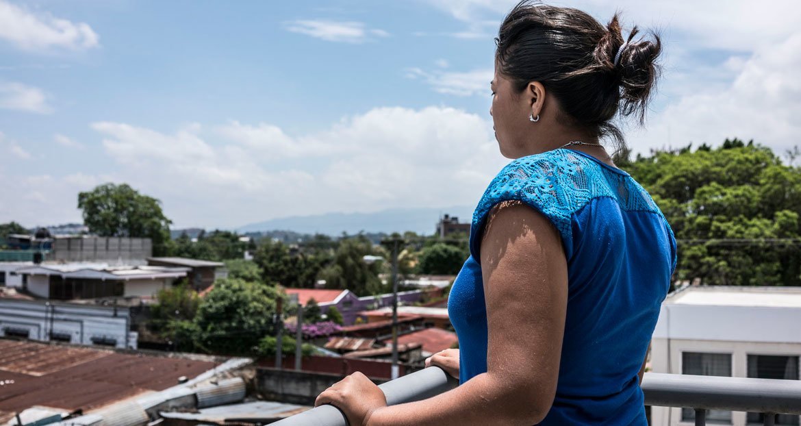 Una adolescente de 15 años mira desde el balcón de un centro de tránsito para migrantes en Ciudad de Guatemala. 