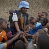 A Rwandan peacekeeper from the UN Multidimensional Integrated Stabilization Mission in Mali (MINUSMA) Formed Police Unit (FPU) speaks with children while patrolling the streets of Gao in northern Mali.