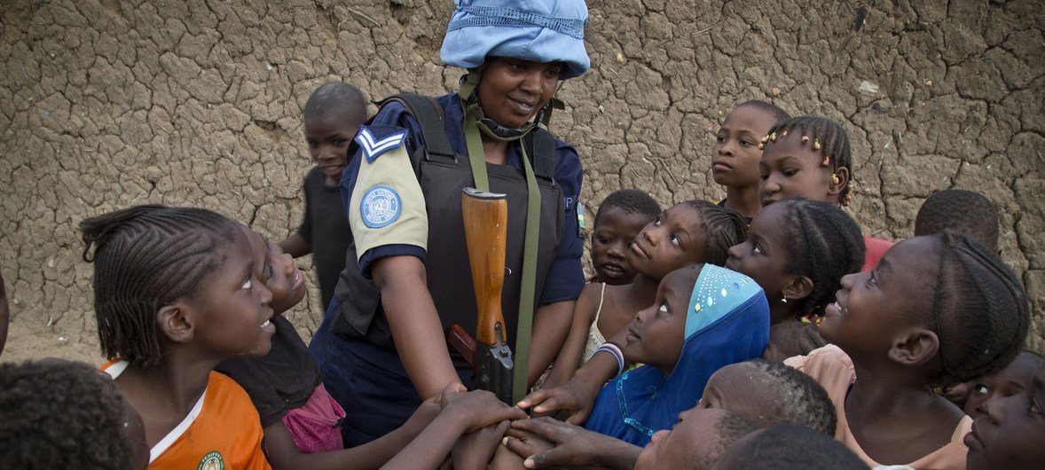 A Rwandan peacekeeper from the MINUSMA Formed Police Unit speaks with children while patrolling the streets of Gao in northern Mali.