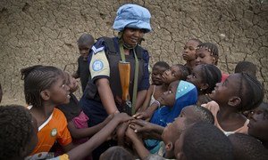 A Rwandan peacekeeper from the UN Multidimensional Integrated Stabilization Mission in Mali (MINUSMA) Formed Police Unit (FPU) speaks with children while patrolling the streets of Gao in northern Mali.