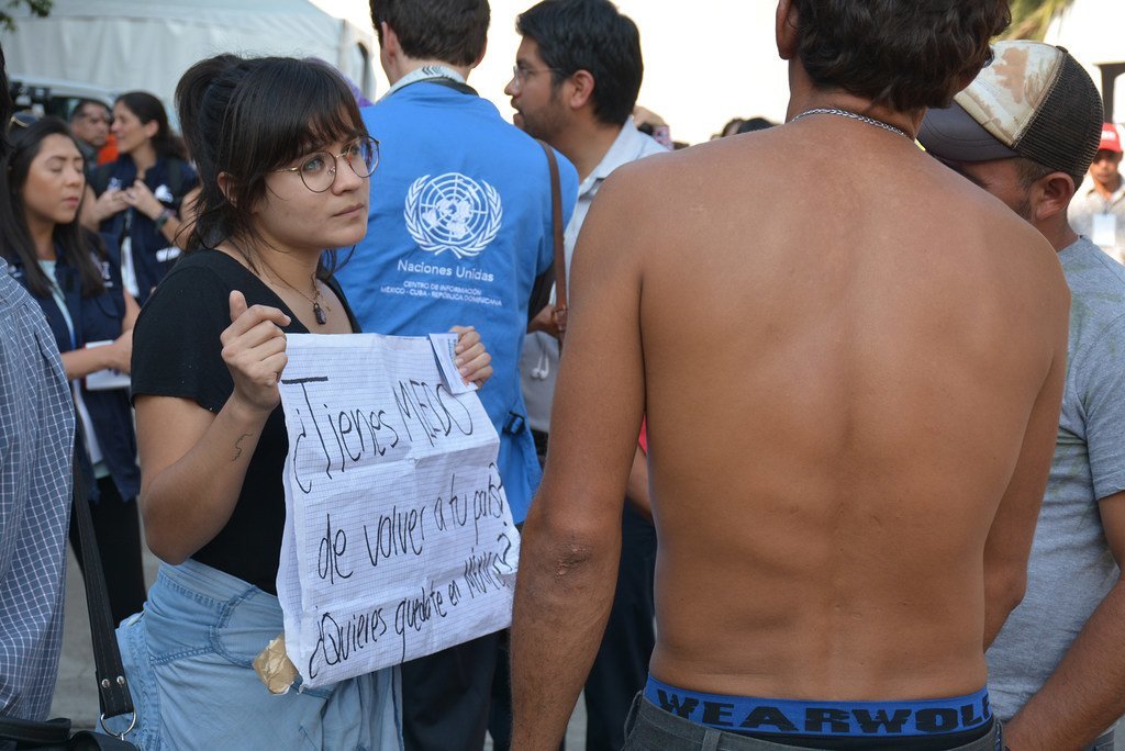 Des migrants d'Amérique centrale au stade Jesús Martínez 'Palillo' situé à l'est de la ville de Mexico. Une femme circule avec une affiche avec le message : « Avez-vous peur de retourner dans votre pays ? » 6 octobre 2018.