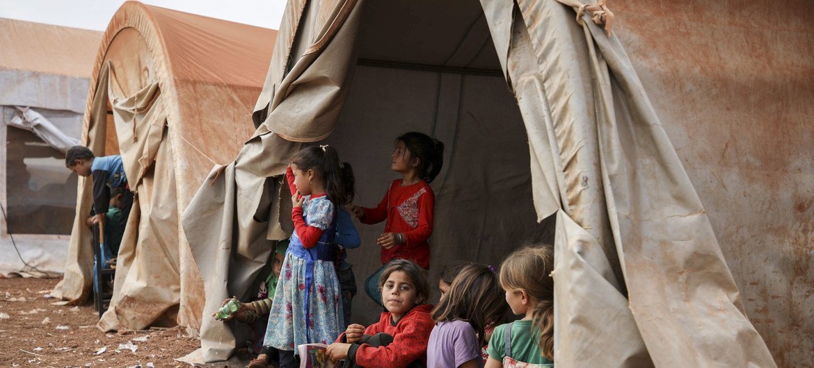 Girls sit in a makeshift tent camp in the north of Syria. 2018