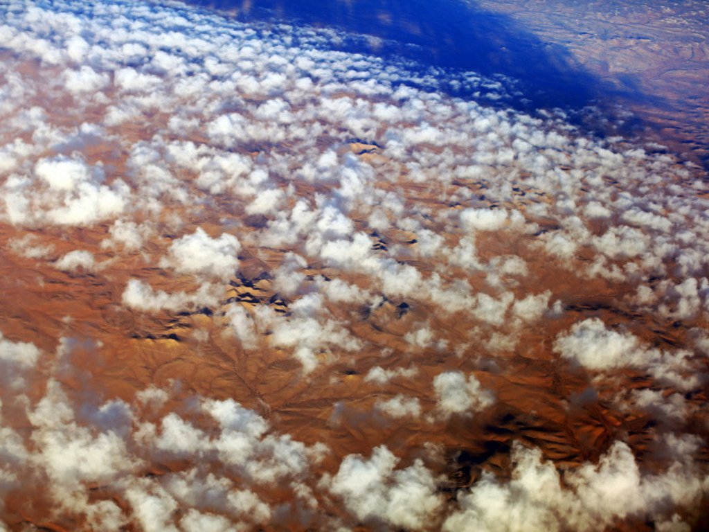 Clouds over the desert in southern Libya. Deserts form a large part of the country and human settlements are mostly found around oases.