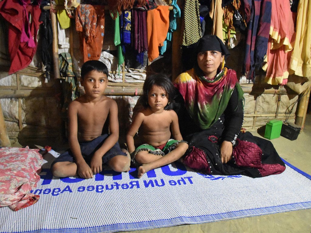 A Rohingya refugee from Myanmar, sits with two out of her four children in their shelter at Nayapara camp, south-east Bangladesh.