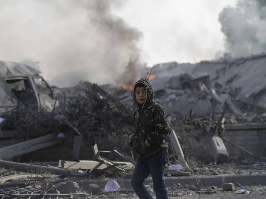 2012年11月，在加沙地带南部的拉法城，一个12岁的男孩走过被以色列空袭摧毁的房屋。