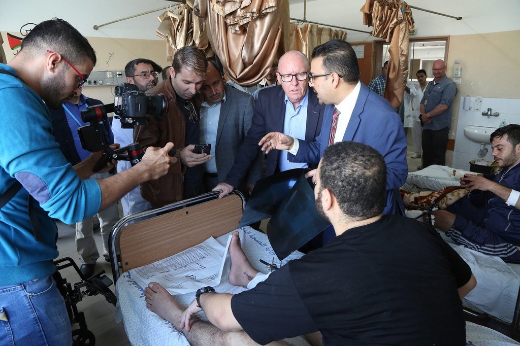 Jamie McGoldrick (au centre), le Coordinateur humanitaire des Nations Unies pour le Territoire palestinien occupé, rend visite à des patients de l'hôpital Al-Shifa à Gaza, en présence de médecins et du représentant de l'OMS.