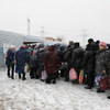 People wait in line at Maiorske Entry/Exit Checkpoint in eastern Ukraine