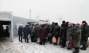 People wait in line at Maiorske Entry/Exit Checkpoint in eastern Ukraine