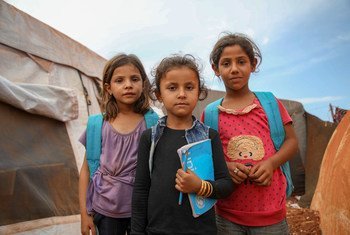 فتيات سوريات يرتدين حقائب ظهر بشعار اليونسف خارج مدرسة مشيدة من الخيام، في مخيم جونايا المؤقت في ريف إدلب الشمالي، حيث يتعلم 350 طفلا من سن 7 إلى 14 عاما.