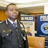 Vence Gariba, um policial da ONU da Guiné-Bissau, está em um escritório com faixas atrás dele.